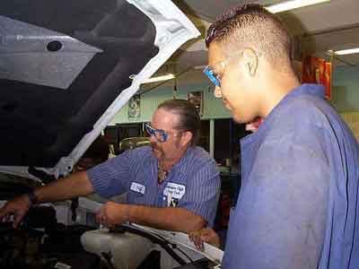 A student and teacher working on a car in the Auto Shop.