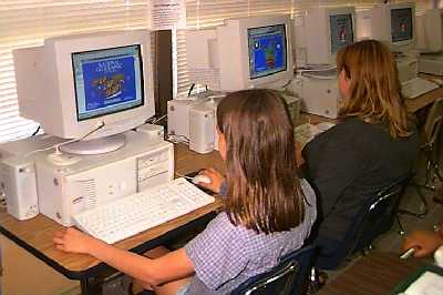 Geography students search computer atlas.