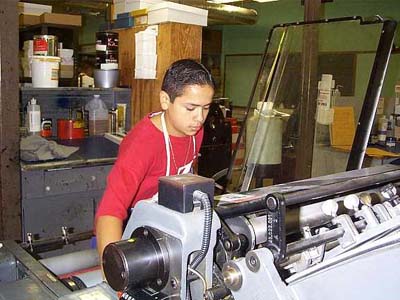 A student working at the Johnston High Print Shop.