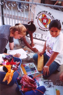 Sarah helping a kid make a quilt square